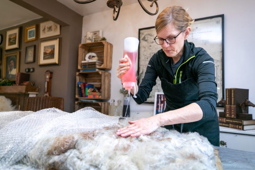 Trish O'Meara at work creating sheep fleece rugs in her Wormit home. 