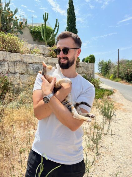 Rob Lindsay with a stray cat in Cyprus