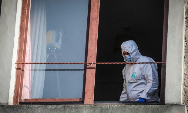 A forensics officer inside the Morgan Street flat on Wednesday. Image: Mhairi Edwards/DC Thomson