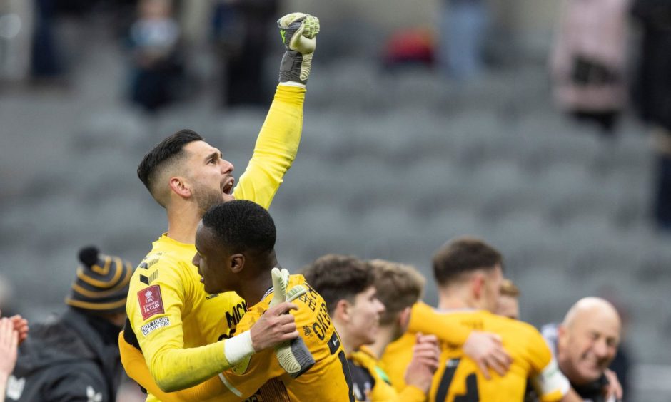 Dimitar Mitov celebrates with his Cambridge United team-mates after beating Newcastle in the FA Cup.