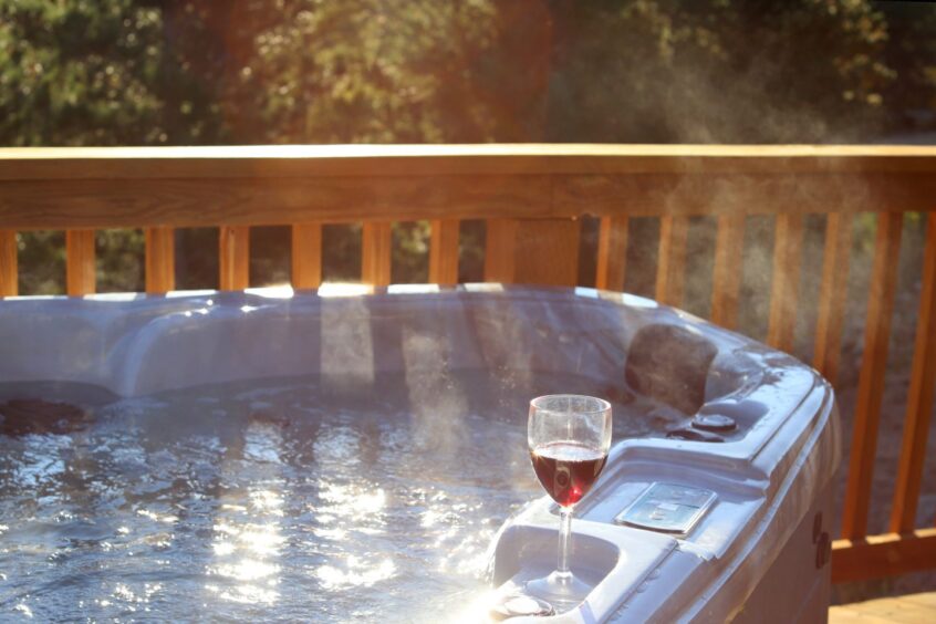 Hot tub on terrace with glass of wine on side