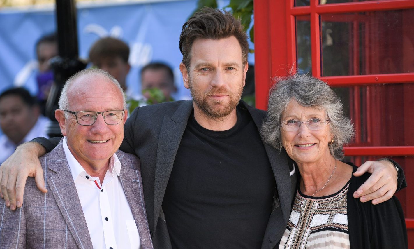 Ewan McGregor with parents Jim and Carol on a red carpet at a film screening.