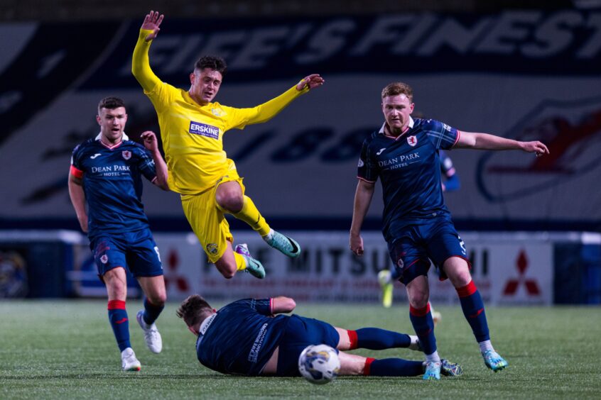 Euan Murray slides into to another challenge as Morton substitute Michael Garrity hurdles over the Raith Rovers defender.