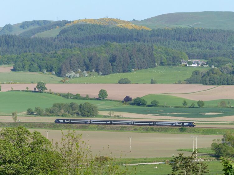 The high-speed train passes through countryside at Forteviot. 