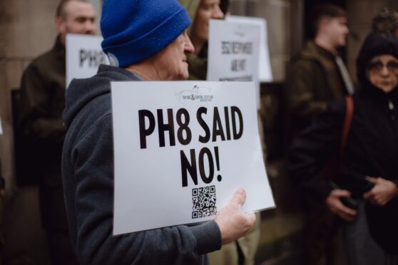 Protester holding placard which reads 'PH8 said no'