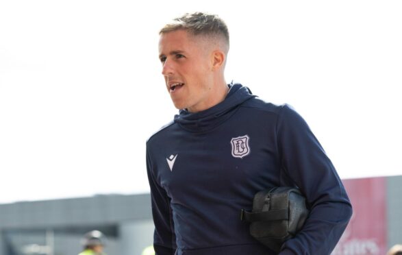 Dundee FC player Luke McCowan with his bootbag under his arm and training kit on.