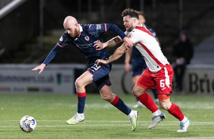 Raith Rovers striker Zak Rudden keeps his eyes on the ball as he holds off Airdrie defender Callum Fordyce.