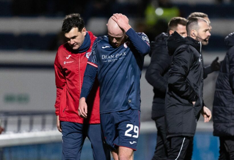Flanked by manager Ian Murray, Zak Rudden holds his hand to his head and looks to the ground after being substituted with a hamstring problem in the recent defeat to Airdrie.