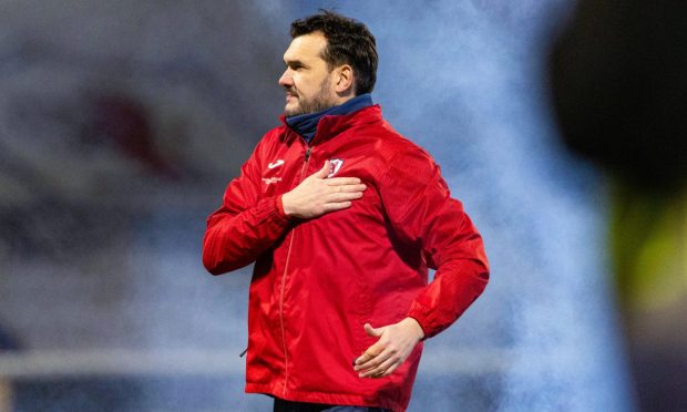 Ian Murray celebrates Raith Rovers' last win over Dundee United as he places his right hand on the club's badge on his red jacket.