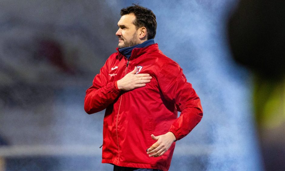 Ian Murray celebrates Raith Rovers' last win over Dundee United as he places his right hand on the club's badge on his red jacket.