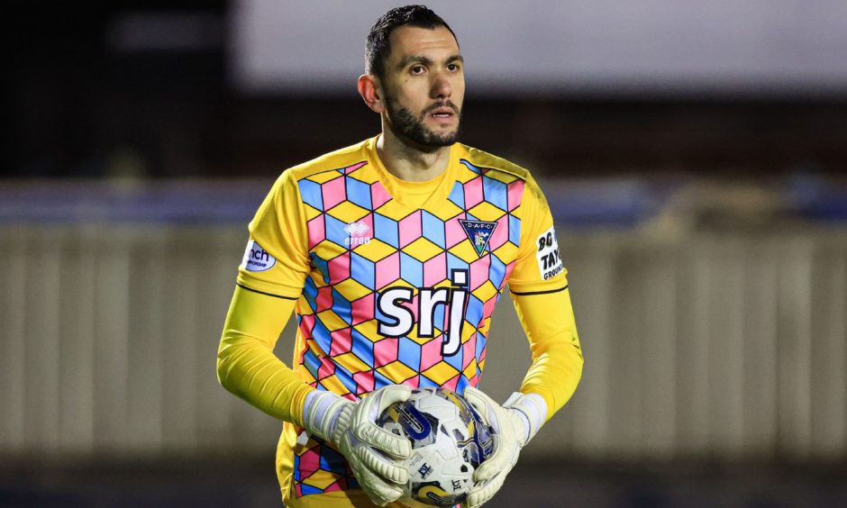 Dunfermline Athletic F.C. goalkeeper Deniz Mehmet clutches the ball.