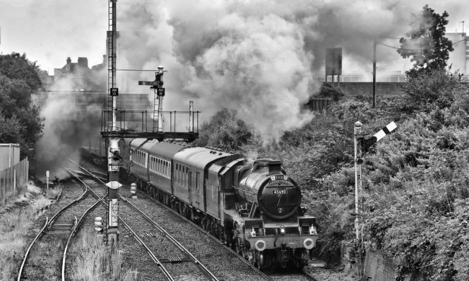 Mike Cooper's photo of 45690 Leander at Arbroath in July 2023 show steam coming from its funnel as it passes a grassy bank