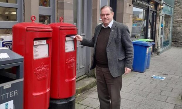 John Duff standing next to red post box outside Aberfeldy post office