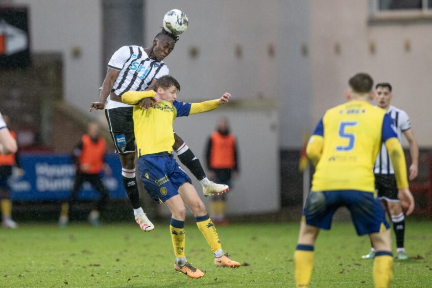 Dunfermline midfielder Ewan Otoo rises high with determination to win a header.