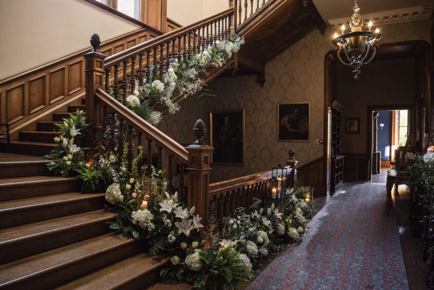 Cambo House staircase decorated with flowers.
