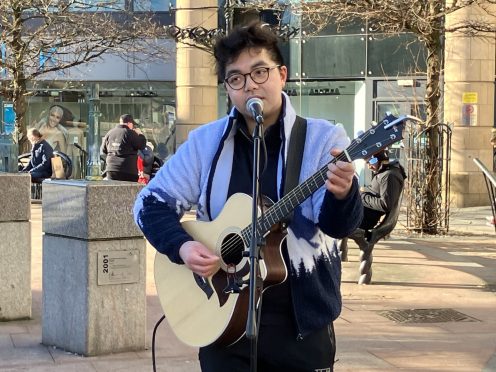 Spencer Shek sings romantic ballads outside the Dundee Overgate. Image: Finn Nixon/DC Thomson.