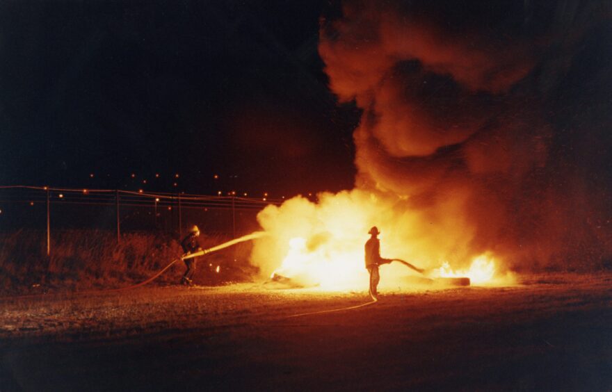 Firefighters put out the flames in an accident simulation at Dundee Airport in 1990. 