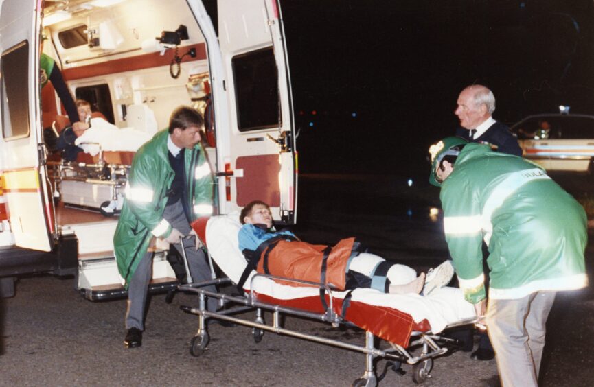 A casualty on a trolley is put into an ambulance