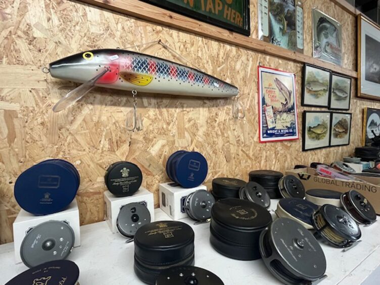 Fishing reels, an ornamental fishing fly and framed pictures of fish