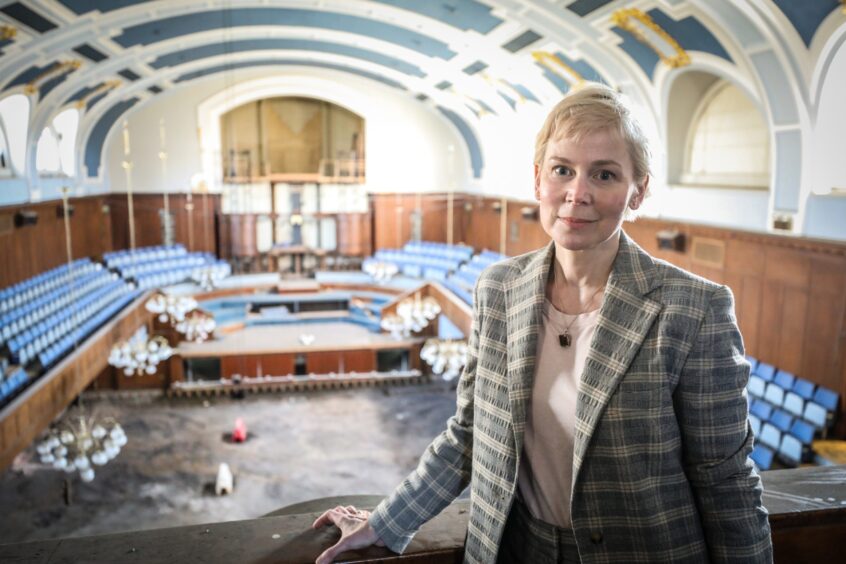 Fiona Robertson inside the City Hall before its £27M transformation, with old rows of seating and stripped back fittings