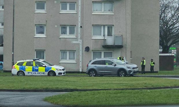 Police at a block of flats on Earn Road.