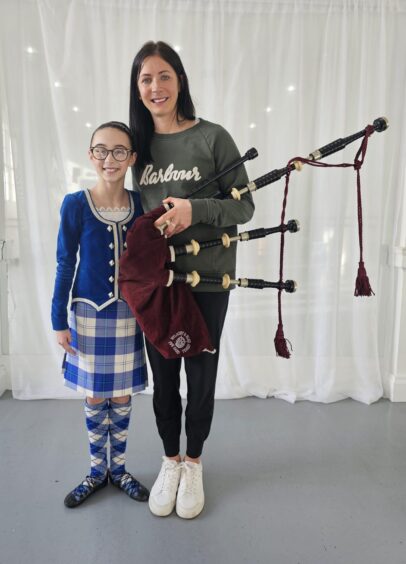 Millie Nicolson and Eve Muirhead, holding bagpipes