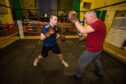 Arbroath Amateur Boxing Club head coach Jamie Norman in the training ring with 15-year-old Alfie Robertson. Image: Steve MacDougall/DC Thomson