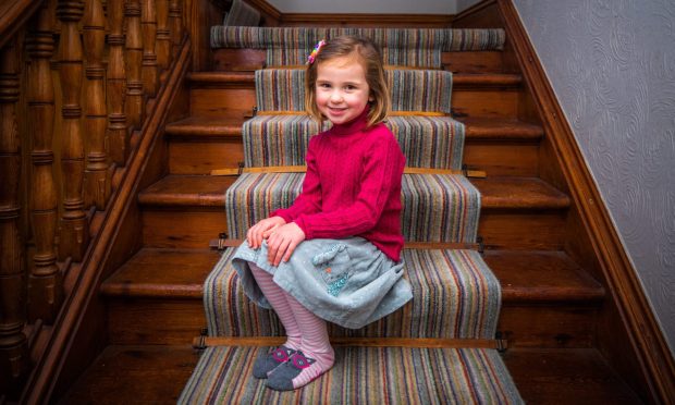 Cassie Doyle, sitting on staircase, is among children still impacted by Covid lockdown.