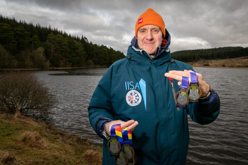 Euan shows off his haul of medals - won at the first ever European Ice Swimming Championships. Image: Steve Brown.