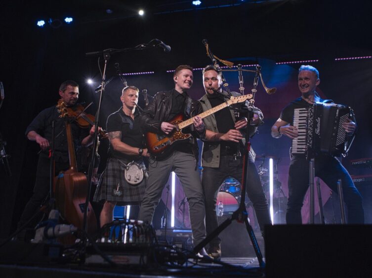 The band Skerryvore on stage playing traditional Scottish instruments