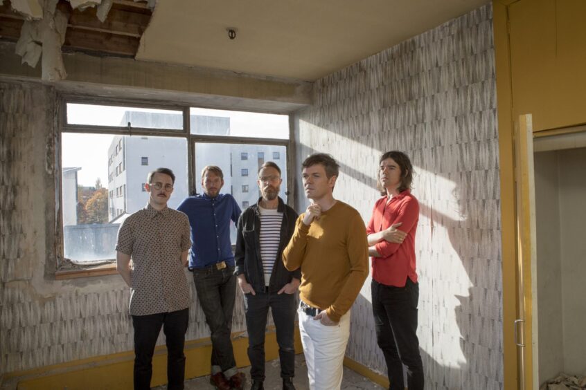 The band Idlewild in a publicity shot photographed inside an empty high rise flat with peeling wallpaper