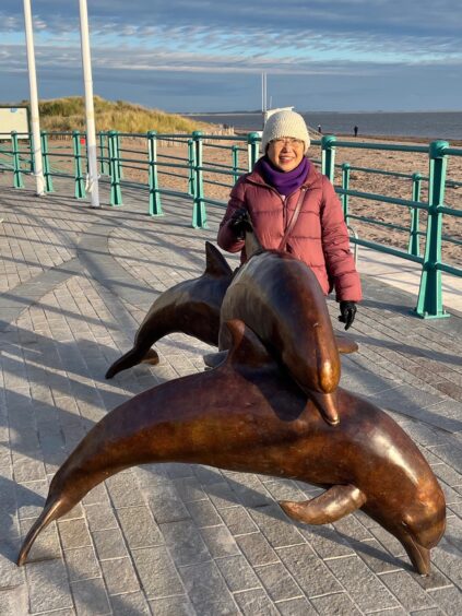 Fanny Christie with the 'Tay Fins' statues in Broughty Ferry. 