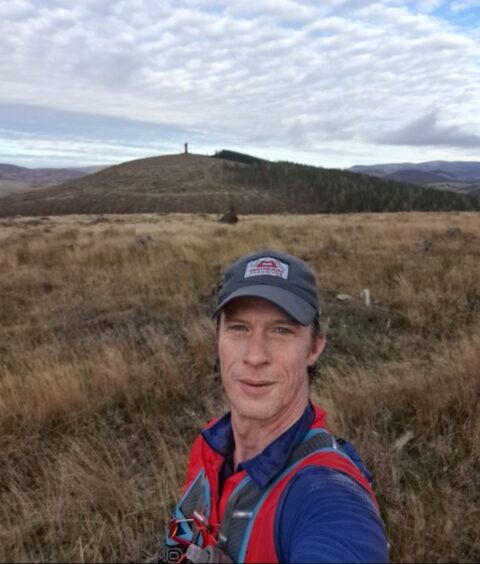 Police Scotland (Tayside) Mountain Rescue Team leader Paul Morgan taking selfie with Scottish landscape behind him