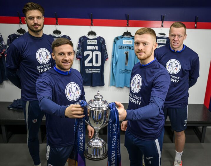 Raith Rovers players Kevin Dabrowski, Lewis Vaughan, Callum Smith and Scott Brown pose with the SPFL Trust Trophy in the Stark's Park dressing room.