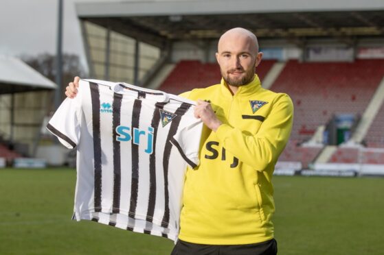 Chris Kane holds up a Dunfermline Athletic F.C. jersey.