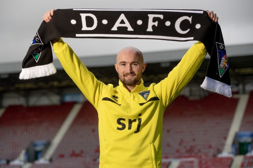 Chris Kane holds a Dunfermline Athletic F.C. scarf above his head after joining on loan from St Johnstone.
