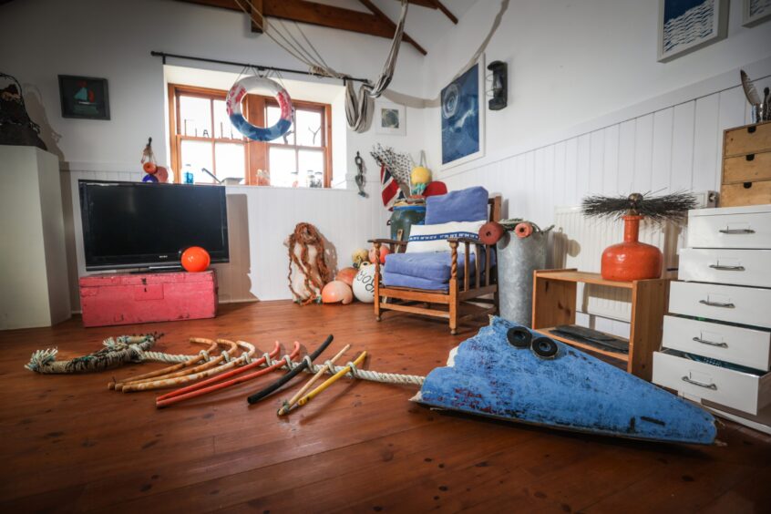 Image shows: Cat Coulter's studio in Cellardyke with some work in progress on the floor. The end of a broken kayak with bits of old creels and rope are being transformed into a huge fish.