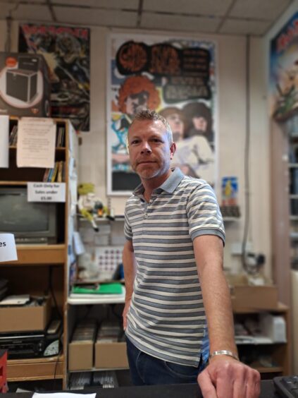 Craig Smith behind counter at Concorde music shop, Perth