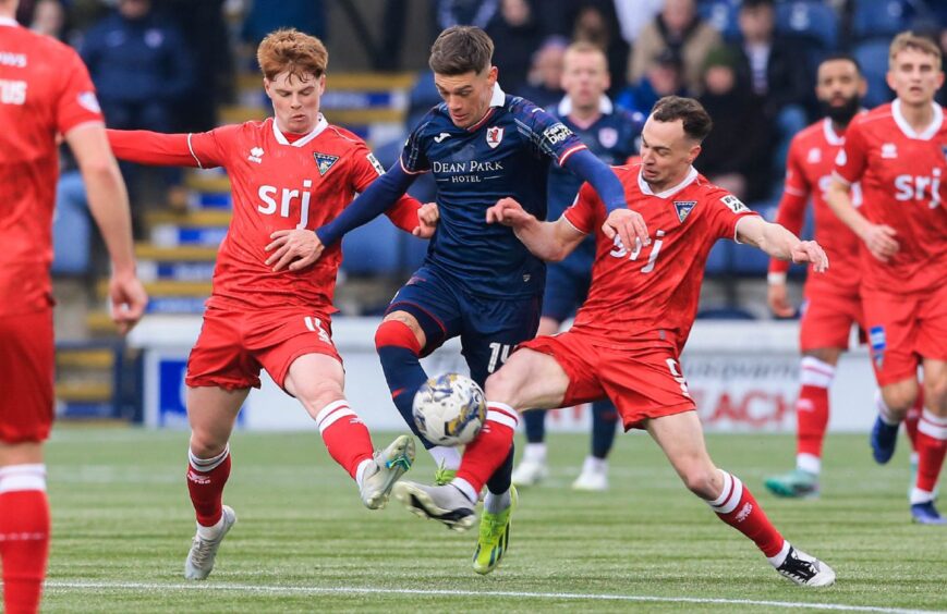 Raith Rovers' Josh Mullin and Dunfermline's Ben Summers and Chris Hamilton battle for possession.
