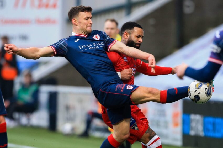 Raith Rovers midfielder Ross Matthews stretches out his right boot to connect with the ball in front of Dunfermline striker Alex Jakubiak.