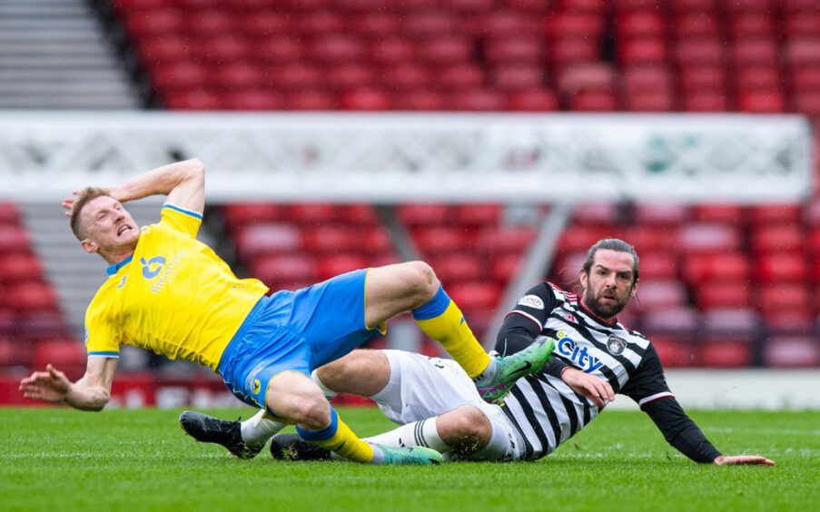 Liam Dick of Raith Rovers and Queen's Park striker Cillian Sheridan tackle each other on the ground.