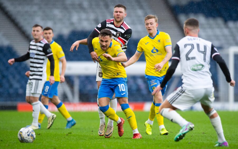 Lewis Vaughan appears to be held back by Queen's Park skipper Dom Thomas as he tries to launch a Raith Rovers attack.