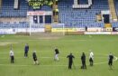 Staff work on the Dens Park pitch before the Dundee-Rangers game was called off. Image: SNS