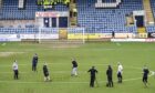 Staff work on the Dens Park pitch before the Dundee-Rangers game was called off. Image: SNS