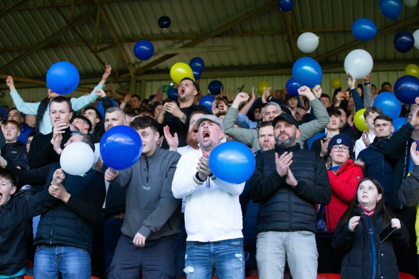 Raith Rovers supporters let off balloons and clap as the teams come out for their match against Dundee United.