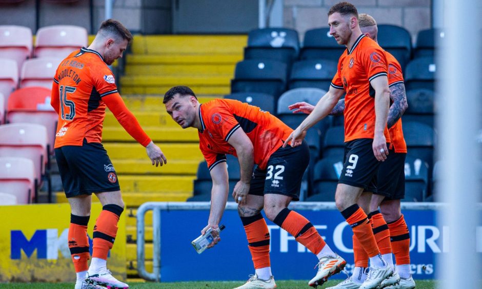 Tony Watt picks up a glass bottle after celebrating Dundee United's opening goal against Raith Rovers.
