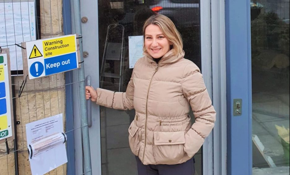 Laura Raimondi outside the restaurant with construction warning signs on the door