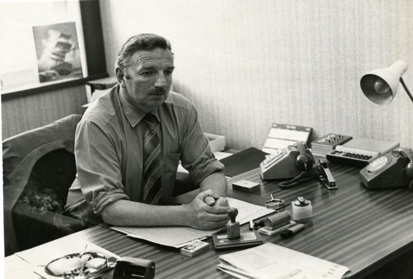 Detective Chief Superintendent James Cameron of Tayside Police sits at his desk in 1980. 
