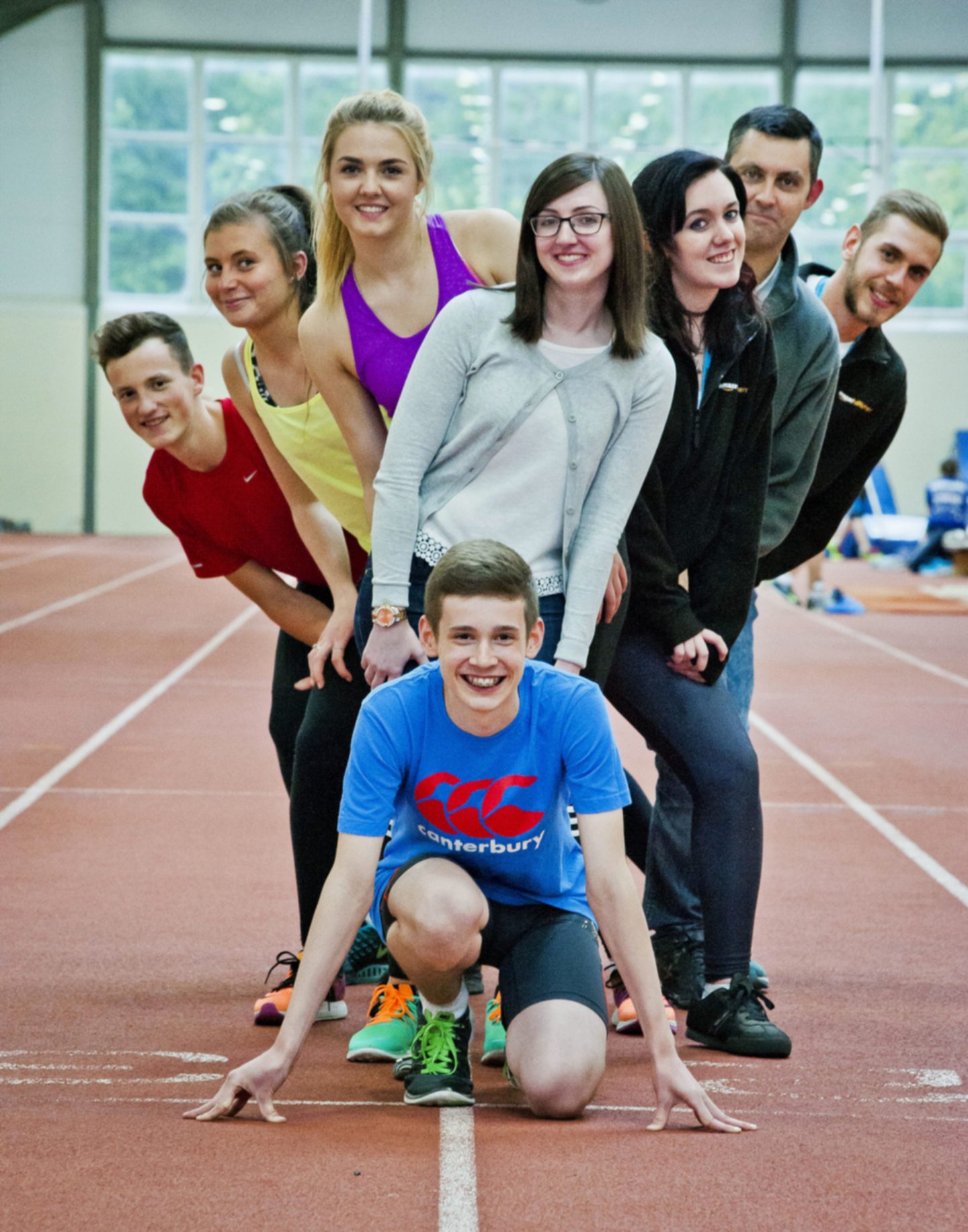 Members of the Pitreavie Amateur Athletic Club in Fife smiling on a running track