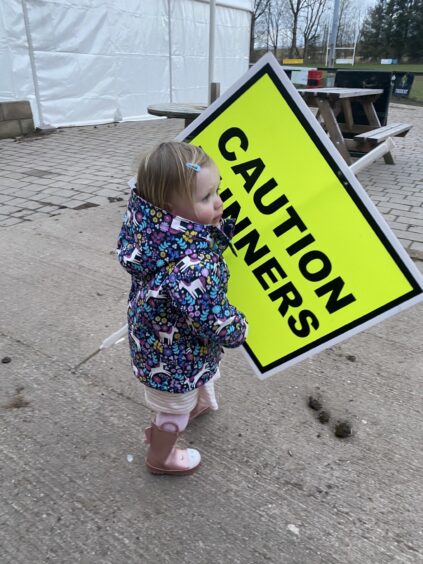One of the Findlay children holding a sign at Forfar Parkrun